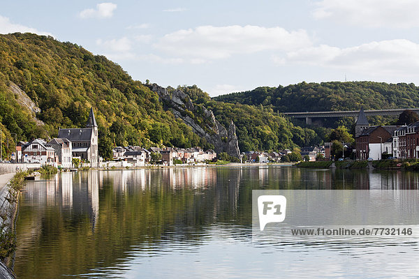 Trees And Buildings Reflected In The Tranquil River Meuse  Dinant Namur Belgium