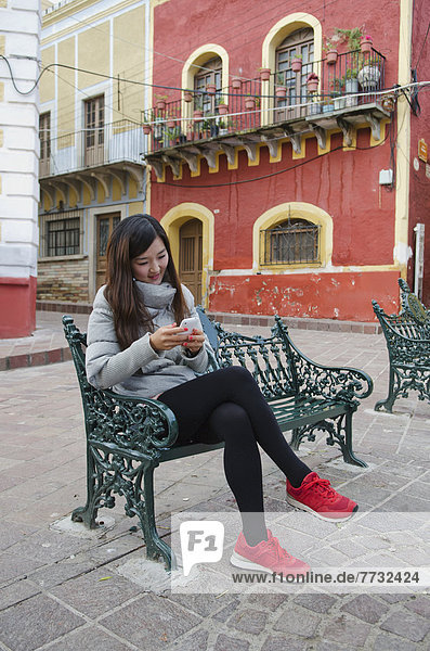 Handy  sitzend  Frau  sehen  Stadt  Sitzbank  Bank  Mexiko  jung  südkoreanisch  Guanajuato  alt  spanisch