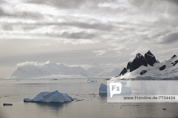 Icebergs And Mountains Along The Coastline  Antarctica