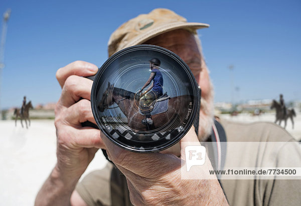 A Man Holds A Camera With A Reflection Of A Young Woman Sitting On A Horse In The Lens  Mijas  Malaga  Andalusia  Spain