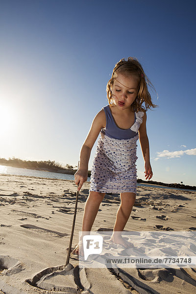 A Young Girl Playing In The Sand At The Beach  Gold Coast Queensland Australia