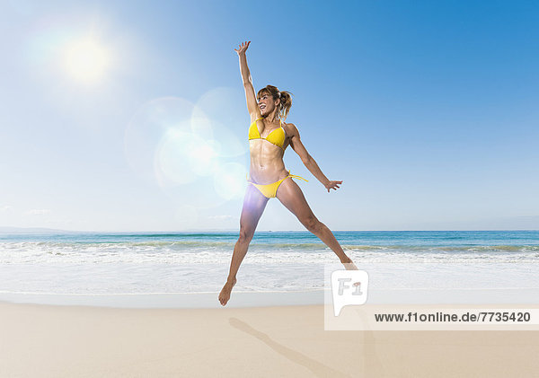 A Woman In A Yellow Bikini Jumps In The Air On The Beach  Tarifa Cadiz Andalusia Spain