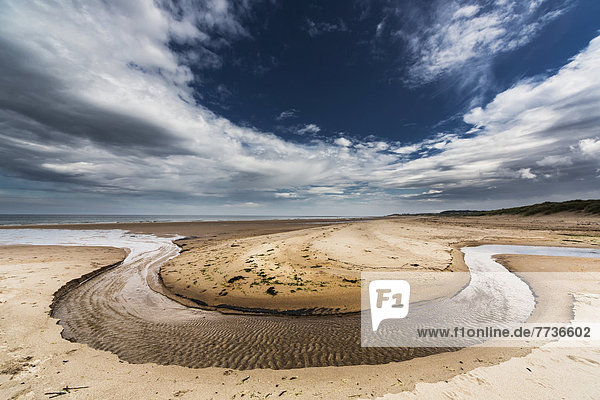 A Stream Formed In A Circular Shape In The Sand Along The Coast  Druridge Bay Northumberland England