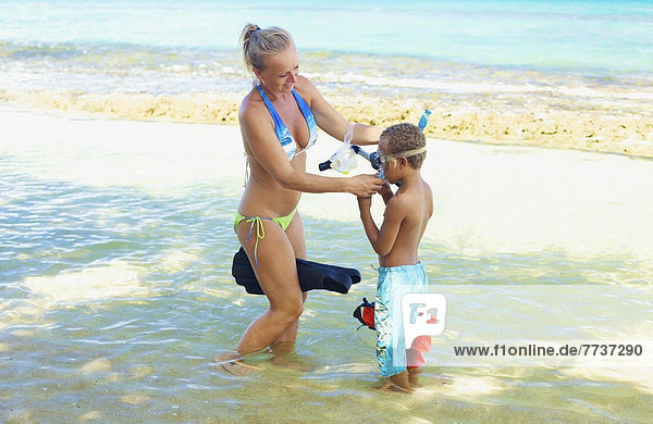 A mother and son with snorkelling gear in the shallow water Hawaii united states of america