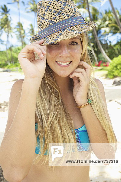 A teenage girl on the beach in a two piece bathing suit and hat Maui hawaii united states of america