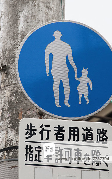 A sign depicting an adult holding a child's hand Nagasaki japan