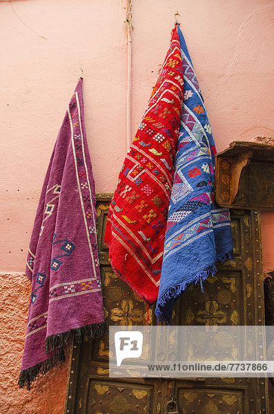 Colourful fabric hung by nails on a wall Marrakech morocco