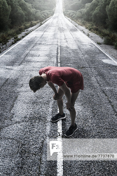A runner stops to take a break on a wet road Tarifa cadiz andalusia spain
