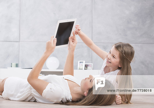 Mutter und Tochter schauen in Tablet-PC