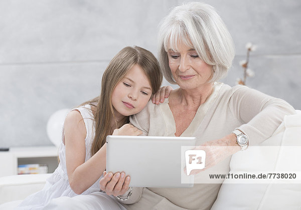 Großmutter und Enkelin schauen in Tablet-PC
