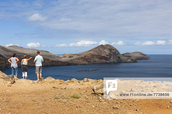 Tourists looking towards the cliffs of the volcanic peninsula of Ponta de Sao Lourenco  nature reserve