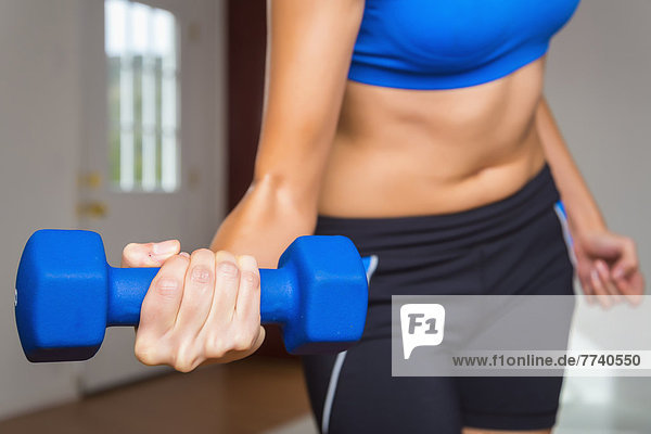 Young woman exercising with hand weight  close up