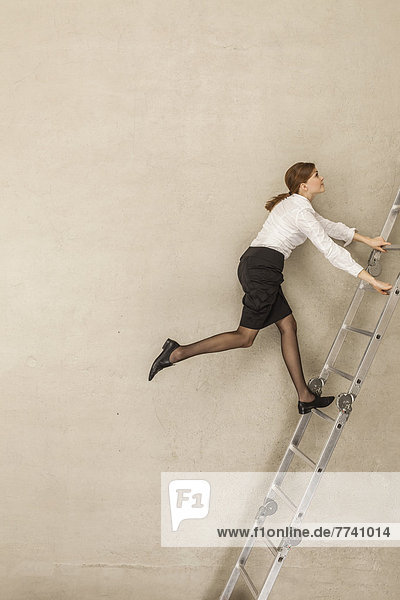 Geschäftsfrau klettert Leiter im Büro
