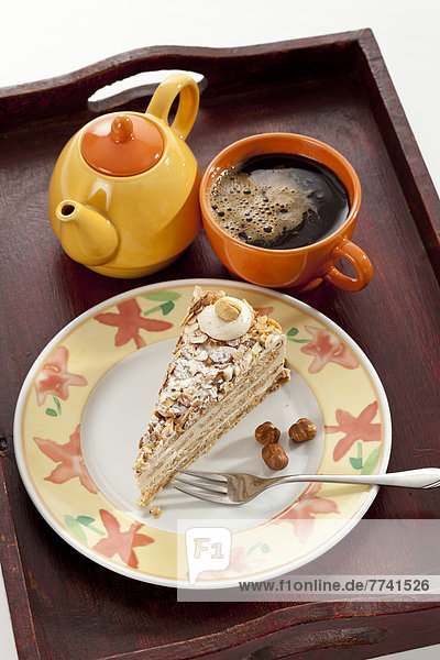 Scheibe Noisette Cake mit Tasse Kaffee im Tablett