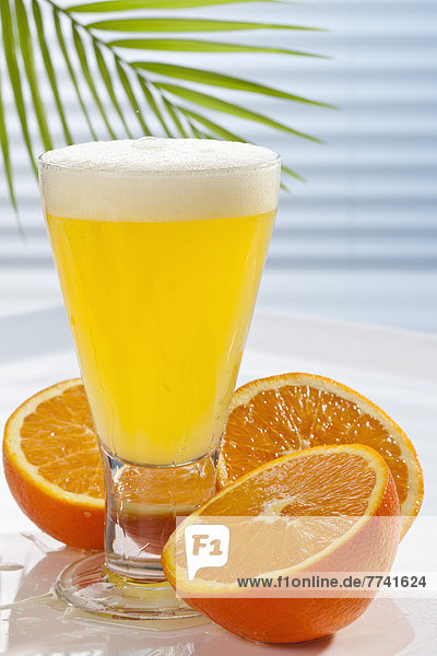 Glas Orangenlimonade neben Orangen auf dem Tisch  Nahaufnahme