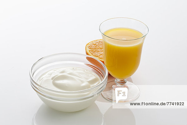 Glas Orangensaft mit Joghurtschale auf weißem Hintergrund  Nahaufnahme