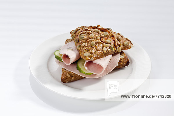 Sandwich aus Vollkornbrot mit Mortadella und Champignons auf dem Teller  Nahaufnahme
