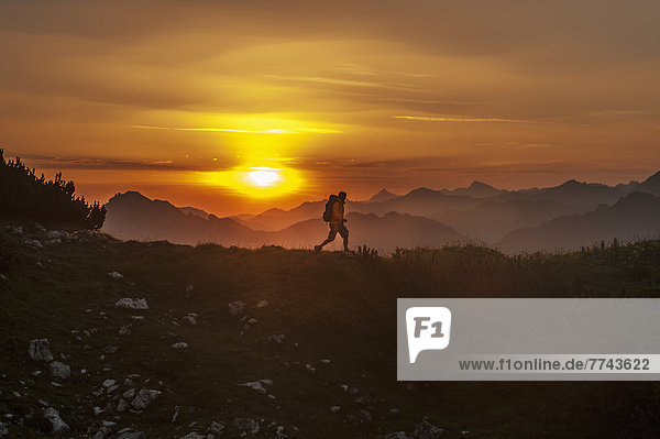 Austria  Salzburg Country  Man hiking through Niedere Tauern mountains at sunrise