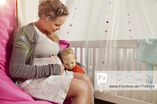 Deutschland  Bonn  Sohn hört auf den Bauch schwangerer Mütter