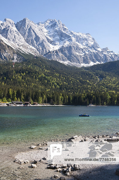 Deutschland,  Bayern,  Blick auf den Eibsee mit Tourist im Tretboot und Zugspitze im Hintergrund