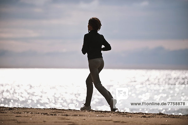 Young Woman Running On The Beach