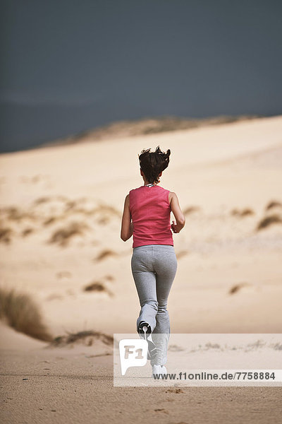 Young Woman Running On The Beach