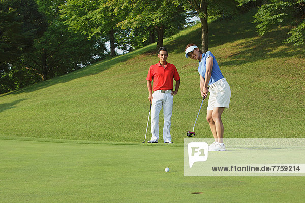 Frau  jung  einlochen  Ball Spielzeug  Golfsport  Golf