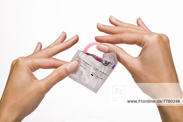 Frauenhände  die ein Kondom halten