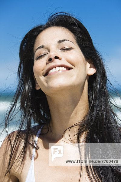 Braunhaarige junge Frau am Strand  Sommer