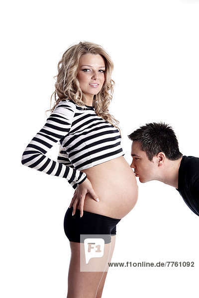 Mann küsst Bauch der schwangeren Frau