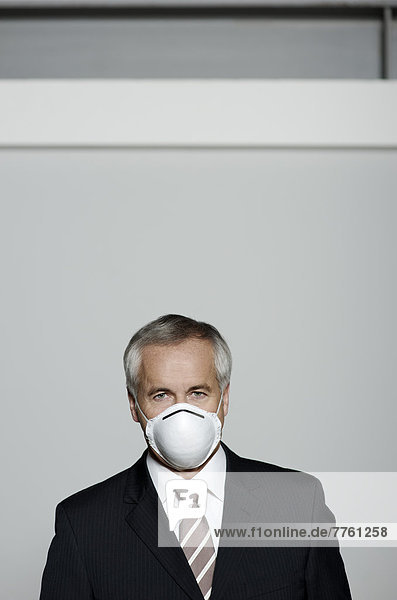 Geschäftsmann mit Schweinegrippe-Maske