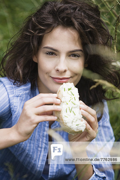 Porträt einer jungen Frau  die Käsetoast isst