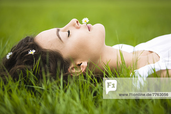 Junge Frau im Gras liegend