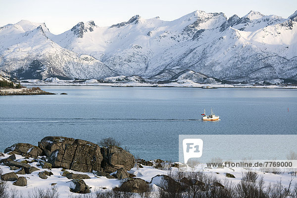 Wintery fjord landscape with a fishing boat