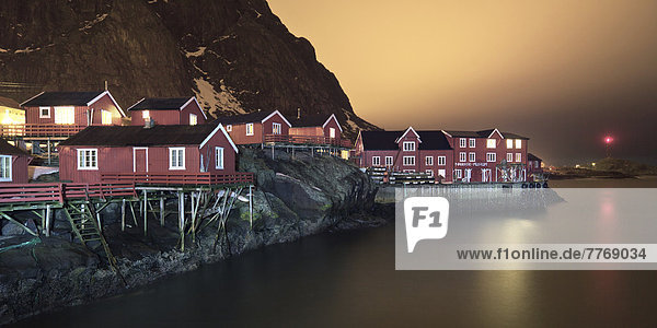 Fishing village with red cottages by the sea  night scene
