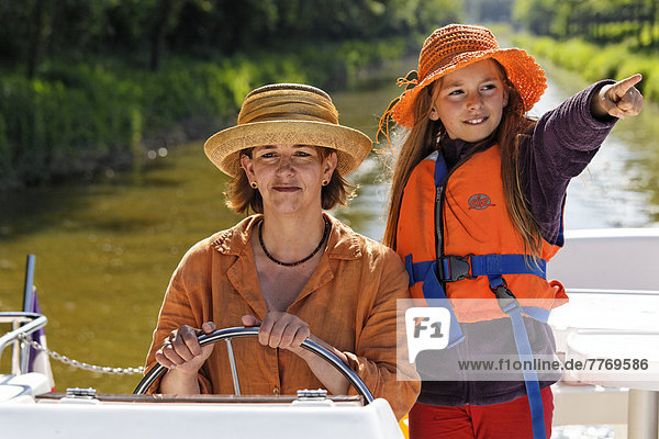 Mutter und Tochter am Steuer einer Penichette Hausboot auf dem Canal de Pont-de-Vaux
