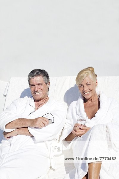 Erwachsenes Paar im Bademantel  auf der Terrasse sitzend