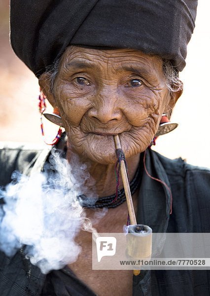 rauchen  rauchend  raucht  qualm  qualmend  qualmt  nahe  Außenaufnahme  Frau  Tradition  Hügel  schwarz  Dorf  Myanmar  Asien  Kleid  Shan Staat  Volksstamm  Stamm