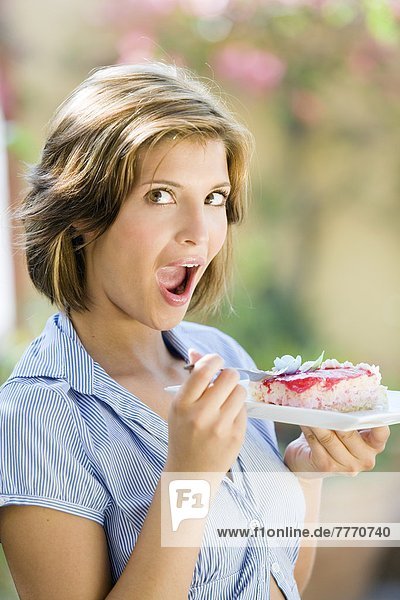 Junge Frau isst Kuchen
