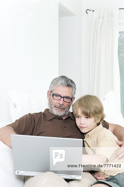 Man and child using laptop