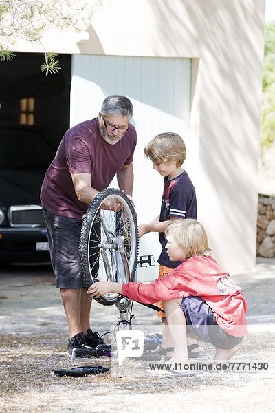 Man and children repairing bike