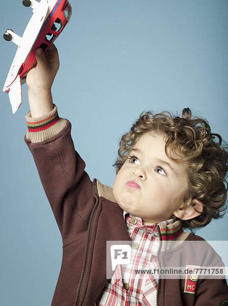 Kleiner Junge spielt mit Spielzeugflugzeug