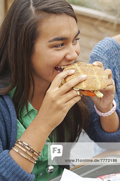 Teenager girl eating an hamburger