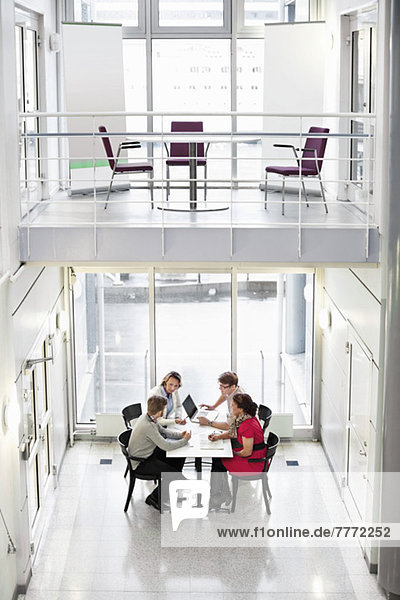 Hohe Blickwinkel von Geschäftsleuten  die am Schreibtisch im Büro diskutieren