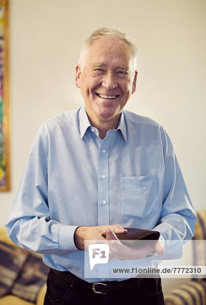 Porträt eines glücklichen älteren Mannes mit Brieftasche in der Hand