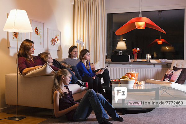 Familie beim gemeinsamen Fernsehen im Wohnzimmer