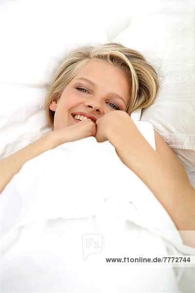 Young woman lying in her bed  smiling