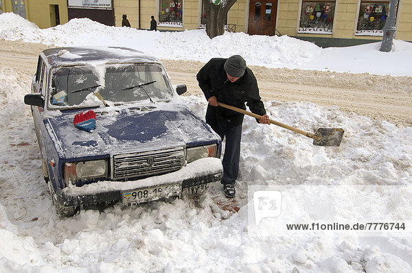 Man clearing car from snow