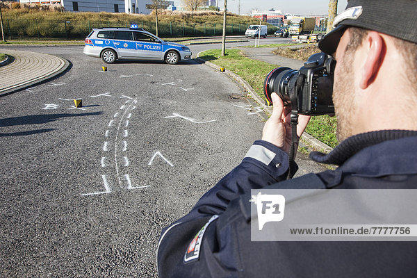 Policeman taking pictures on the scene of a traffic accident