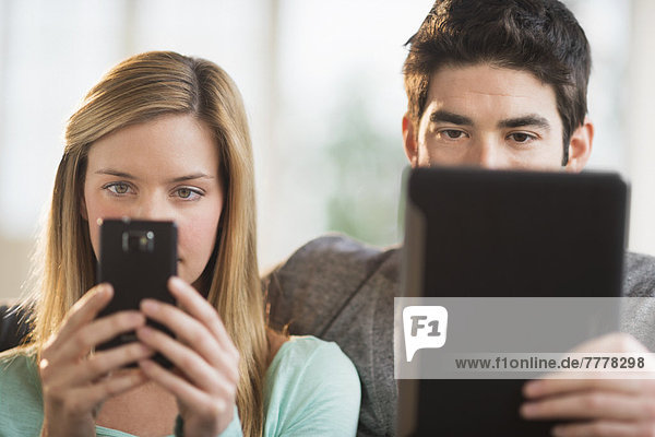 Couple using tablet pc and smartphone